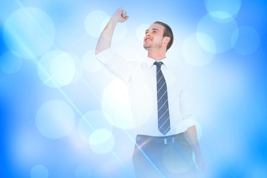 Businessman cheering with clenched fist against blue abstract light spot design