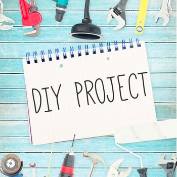 The word diy project against tools and notepad on wooden background