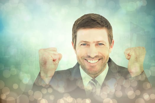 Businessman smiling and cheering against blue abstract light spot design