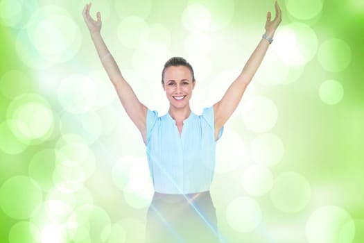 Businesswoman with arms raised against green abstract light spot design