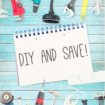 The word diy and save! against tools and notepad on wooden background