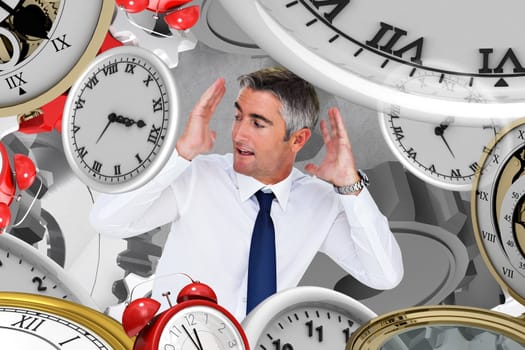 Businessman looking up with arms up against grey background