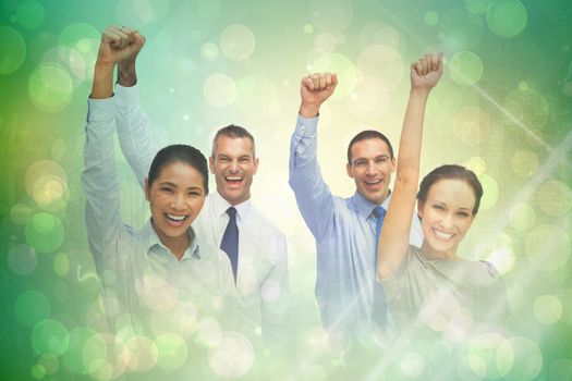 Cheerful work team posing with hands up against green abstract light spot design