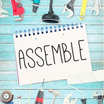 The word assemble against tools and notepad on wooden background