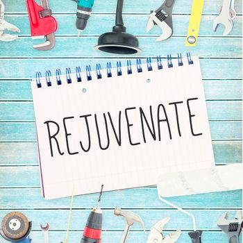 The word rejuvenate  against tools and notepad on wooden background