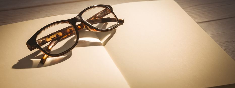 Empty notepad with reading glasses on a desk