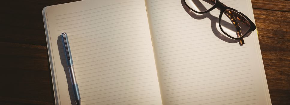 Empty notepad with reading glasses on a desk