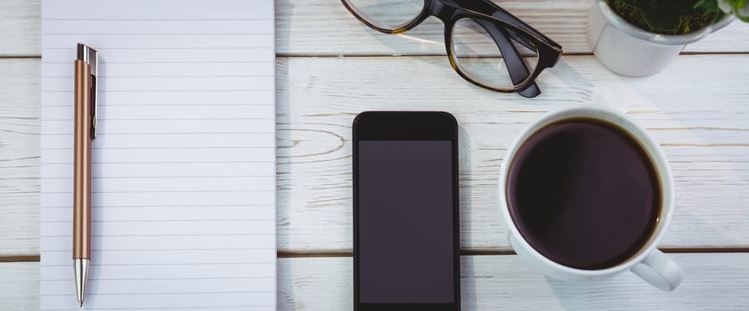 Overhead shot of notepad and smartphone on a desk