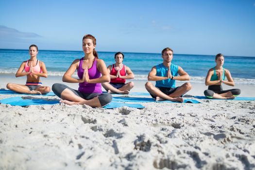 Friends doing yoga together at the beach
