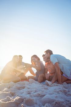 Happy hipsters relaxing and playing guitar at the beach