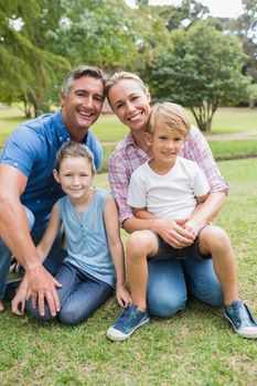 Happy family smiling at the camera on a sunny day