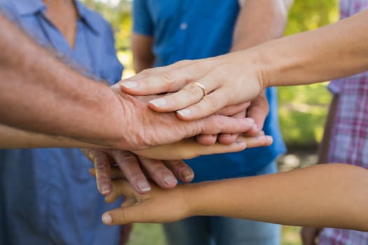 Family putting their hands together on a sunny day