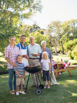 Happy family doing barbecue in the park on a sunny day