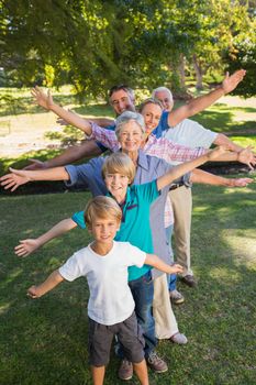 Happy family with arms outstretched in the park on a sunny day