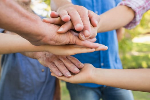 Family putting their hands together on a sunny day