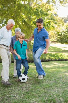 Happy family playing at the ball on a sunny day