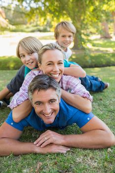 Happy family smiling at the camera on a sunny day