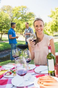 Happy blonde toasting in the park on a sunny day