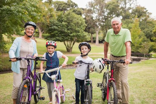 Happy grandparents with their grandchildren on their bike on a sunny day