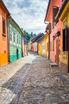 Sighisoara, Romania - June 23, 2013: Stone paved old streets with colored houses from Sighisoara fortresss, Transylvania, Romania