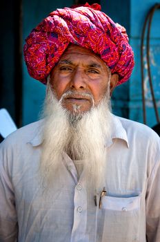 Indian man with white beard in traditional colourful turban portrait Pushkar, India. March 6, 2013