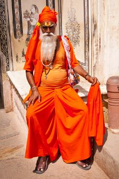 Portrait of undefined indian sadhu - holy man, posing in front of the City Palace, Jaipur, India. April 01, 2012