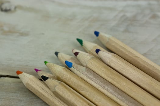 Close f of coloured pencils against a wooden background