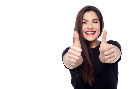 Young woman making thumb up gesture by two hands