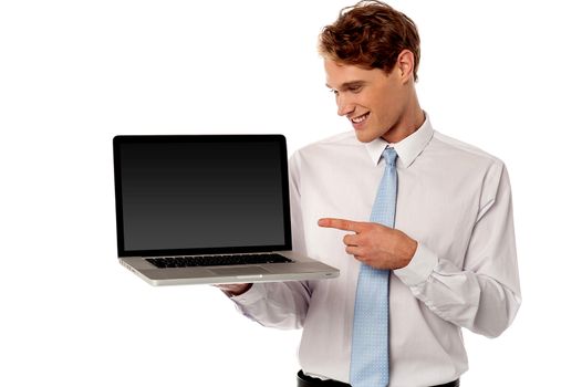 Happy salesman pointing a brand new laptop