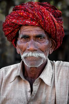 Indian man with moustache in traditional colourful turban portrait Pushkar, India. March 3, 2013