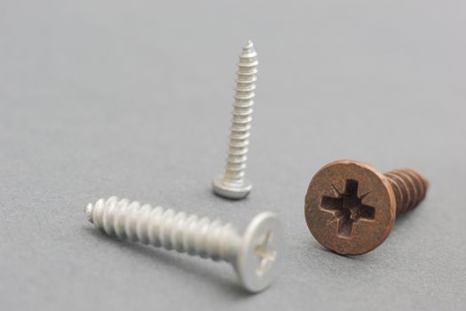 Screws on a gray background as a concept of industry