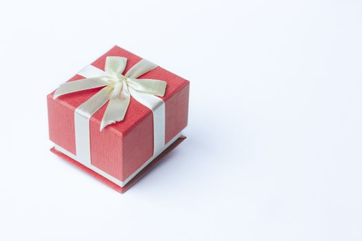 Red gift box tied with a silver ribbon bow. Isolated on white with clipping path