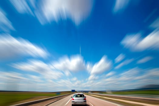 Road trip. Blue sky and car. Motion blur and speed
