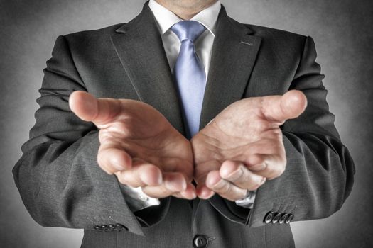 Businessman in dark suit holds out his hands