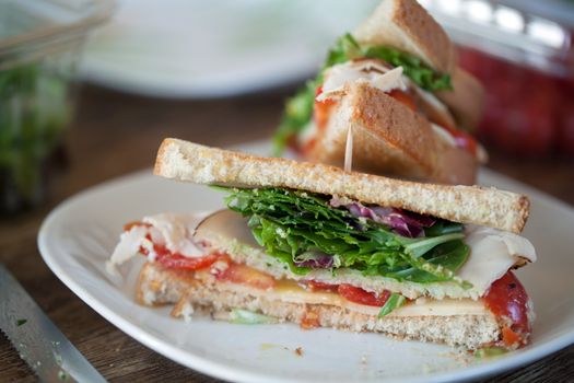 Simple turkey sandwich on honey wheat bread with lettuce and tomato.