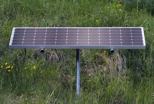 One solar panel standing on the green grass in nature