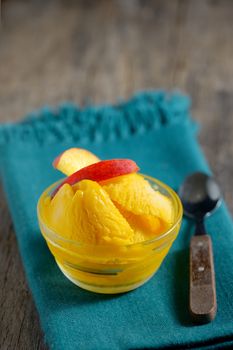 Closeup of a bowl of mango sorbet on old table