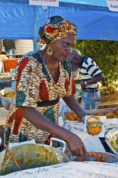 SAO PAULO, BRAZIL - MAY 17, 2015: An unidentified woman preparing typical brazilian food in a stand at a street fair market in Sao Paulo. 