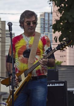 SAO PAULO, BRAZIL - MAY 17, 2015: An unidentified musician playing guitar and singing rock and roll on the street in Sao Paulo, Brazil. 