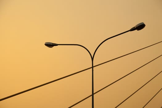 Light pole and rope bridge During the evening, the sun turns orange.