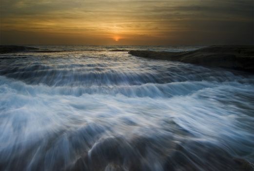 Sunrise seascape with rushing waves