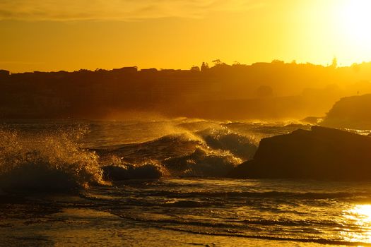 Ocean waves in contrary light with the sun and splashes