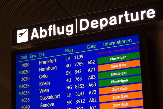 Airport departure board in terminal with flight information