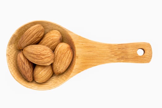almond nut on a small wooden spoon isolated on white with a clipping path