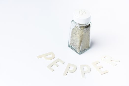Pepper in glass container on white background