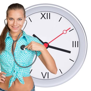 Smiling young woman with stethoscope with clock on background