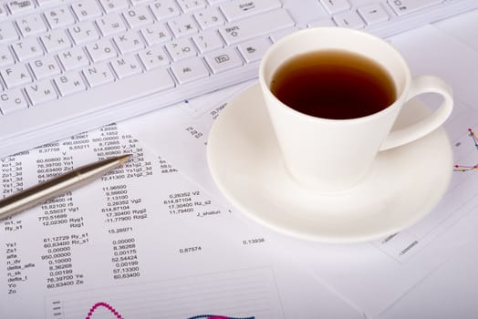 White keyboard with coffee cup and documents