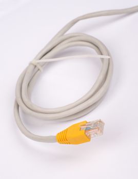 Twisted yellow computer cable on isolated white background, close up view