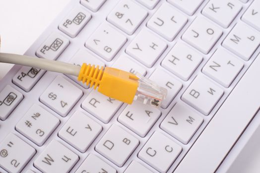 Computer keyboard with yellow cable, close up view