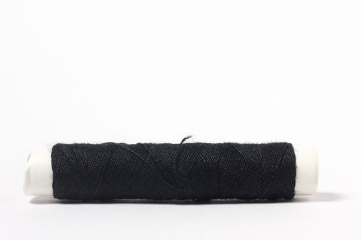 Black cotton thread on a white background